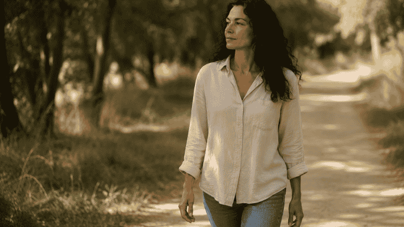 A person taking a mindful walk outdoors in soft daylight, representing daytime stress management as the key to reducing cortisol-driven middle-of-the-night waking
